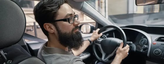 Motorista de aplicativo checando os retrovisores ao fazer uma baliza