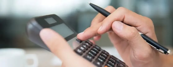 Pessoa utilizando calculadora para descobrir se financiamento de carro vale a pena
