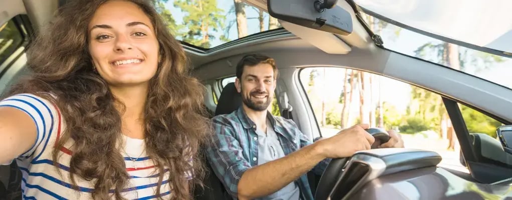 Casal feliz dentro de um carro indo viajar