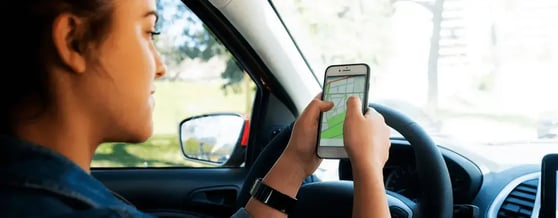 Mulher motorista olhando o aplicativo de navegação dentro do veiculo