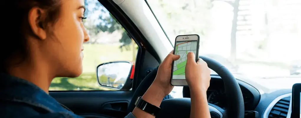 Mulher motorista olhando o aplicativo de navegação dentro do veiculo