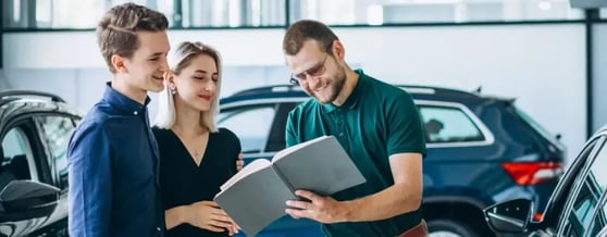 Vendedor explicando os prós e contras da assinatura de carro para um casal interessado
