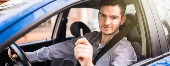 Motorista de aplicativo dentro de veículo alugado segurando a chave