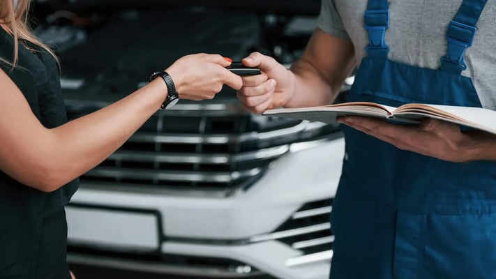 Close de mecânico entregando a chave do carro para mulher motorista de app