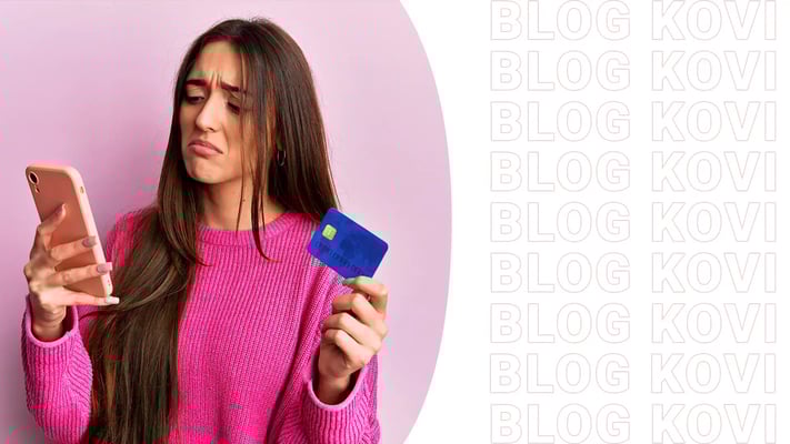 Mulher triste segurando um celular e um cartão de crédito