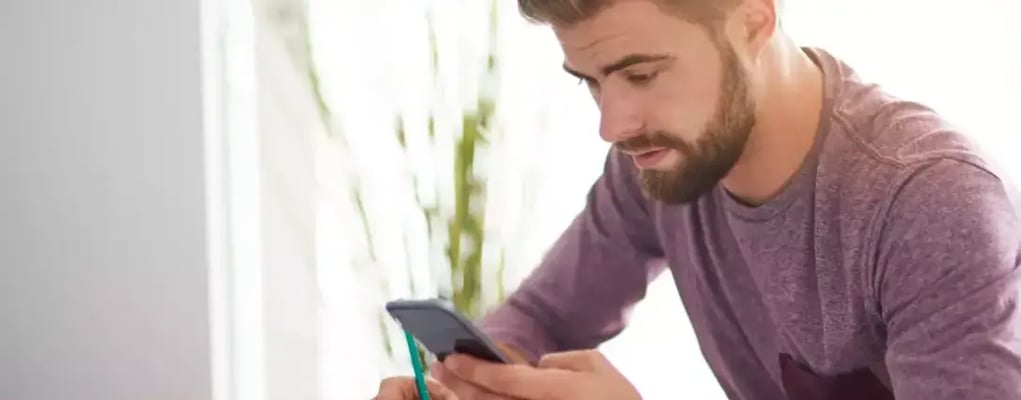 Homem no celular anotando checklist para compra segura de carros