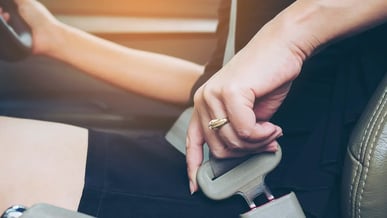 Close de mulher motorista colocando cinto de segurança