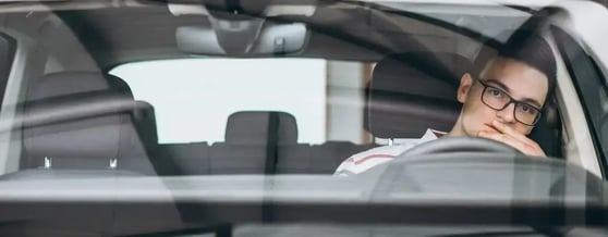 Homem pensativo dentro de um carro