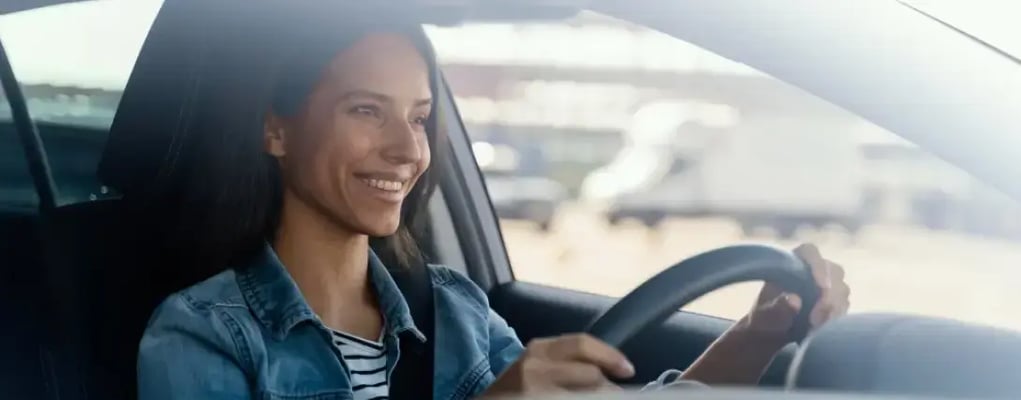 Mulher sorrindo com as mãos no volante, Etios Sedan