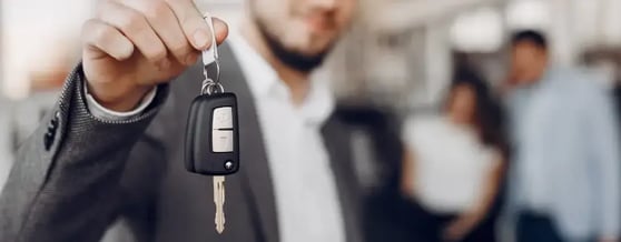Close na mão de um homem segurando chave de carro