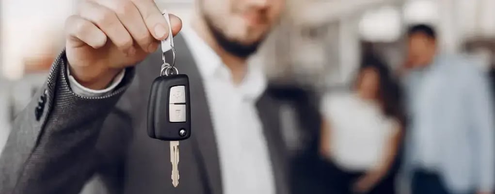 Close na mão de um homem segurando chave de carro