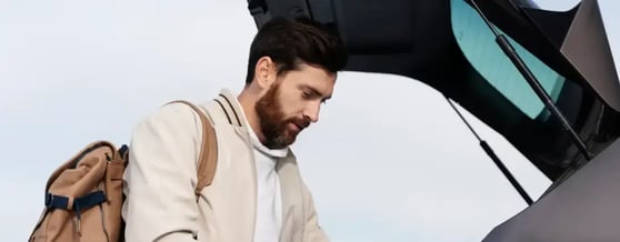 Homem organizando o porta-malas, qual melhor carro para você?