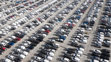 Estacionamento amplo repleto de carros vistos de cima