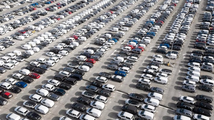 Estacionamento amplo repleto de carros vistos de cima