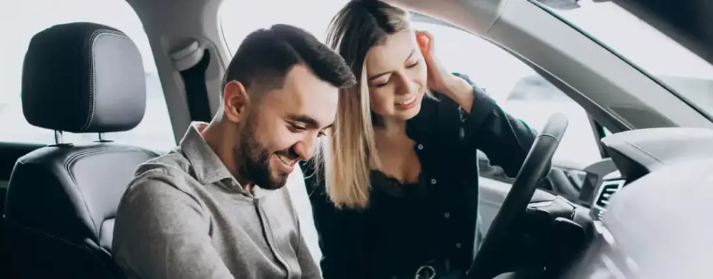 Casal sorrindo dentro do carro