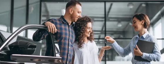 Casal feliz recebendo a chave de seu carro alugado na Kovi