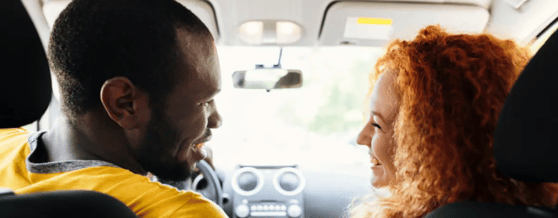 Casal sorrindo dentro do carro