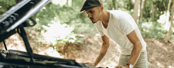 Homem inspecionando o motor do carro