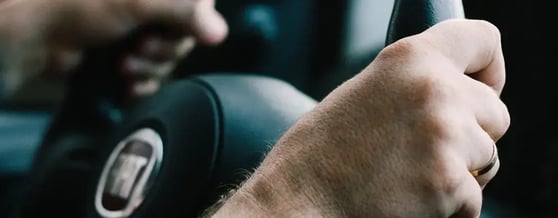 Duas mãos segurando firmemente o volante, Carro Sedan