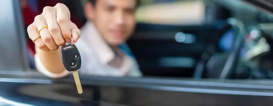 Close na mão de homem segurando a chave de um carro