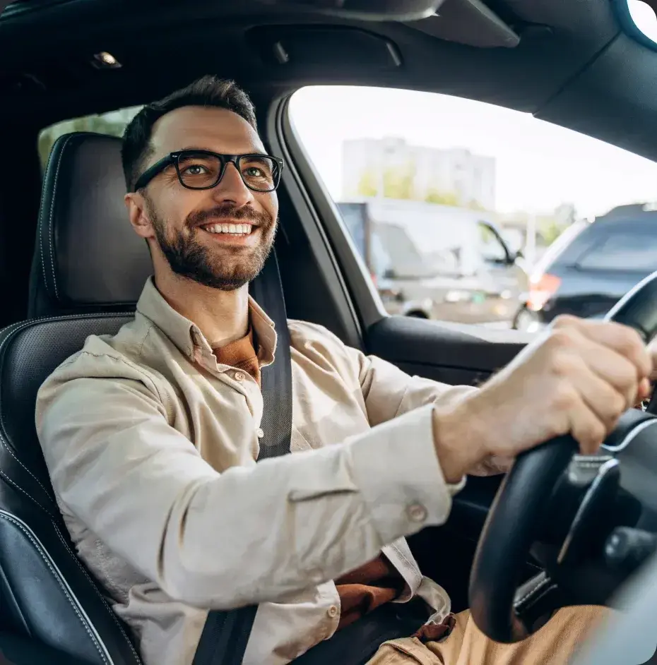 Motorista sorrindo ao volante de um carro Kovi